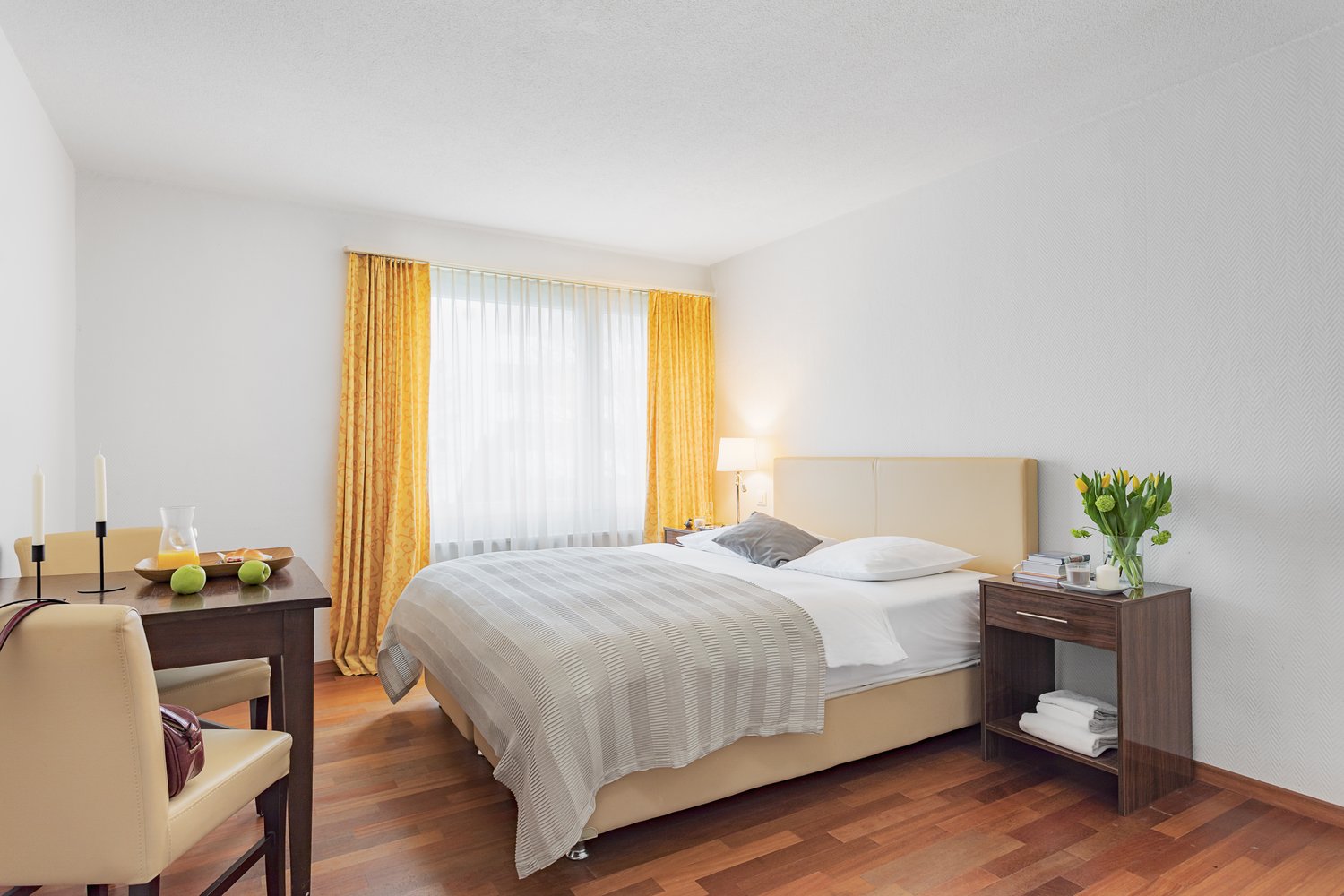 Bed, table, chair, lamp, window, nightstand, yellow curtains, flowers
