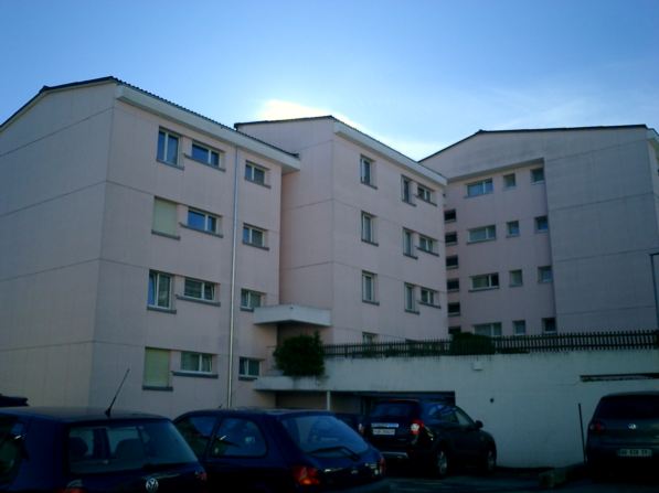 multi story apartment building, several cars parked in front