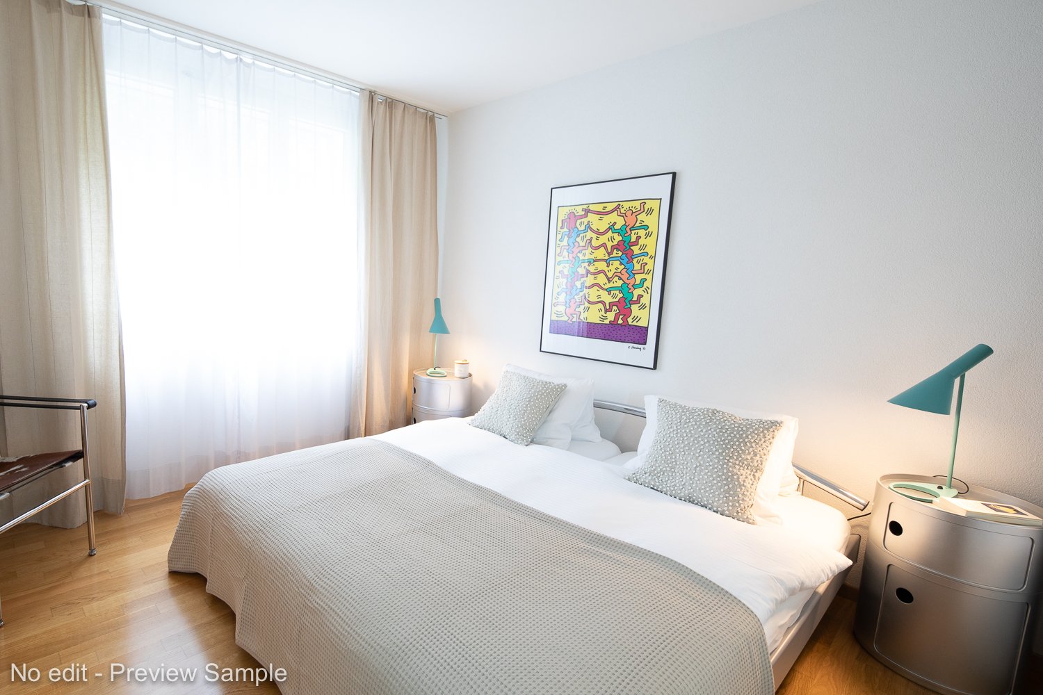 Double bed, pillows, blankets, bedside lamps, night tables, art painting on wall, wooden flooring, chair