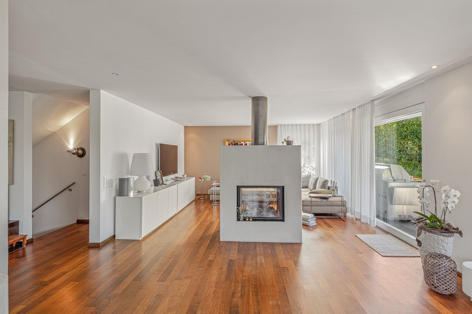 Fireplace, sliding glass doors, hardwood floor, sliding door leading to the bedroom area, lamp, sofa, TV