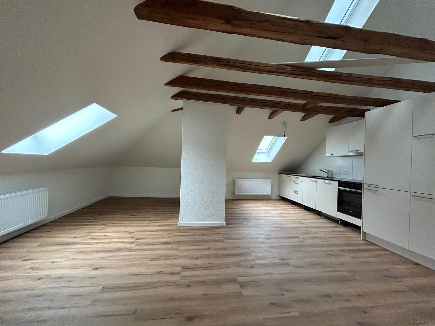 Wooden floor, wooden beams, skylights, kitchen, central pillar