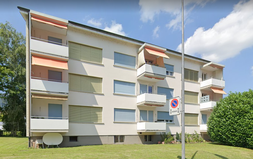 white exterior, balconies, windows with shutters, lawn in front