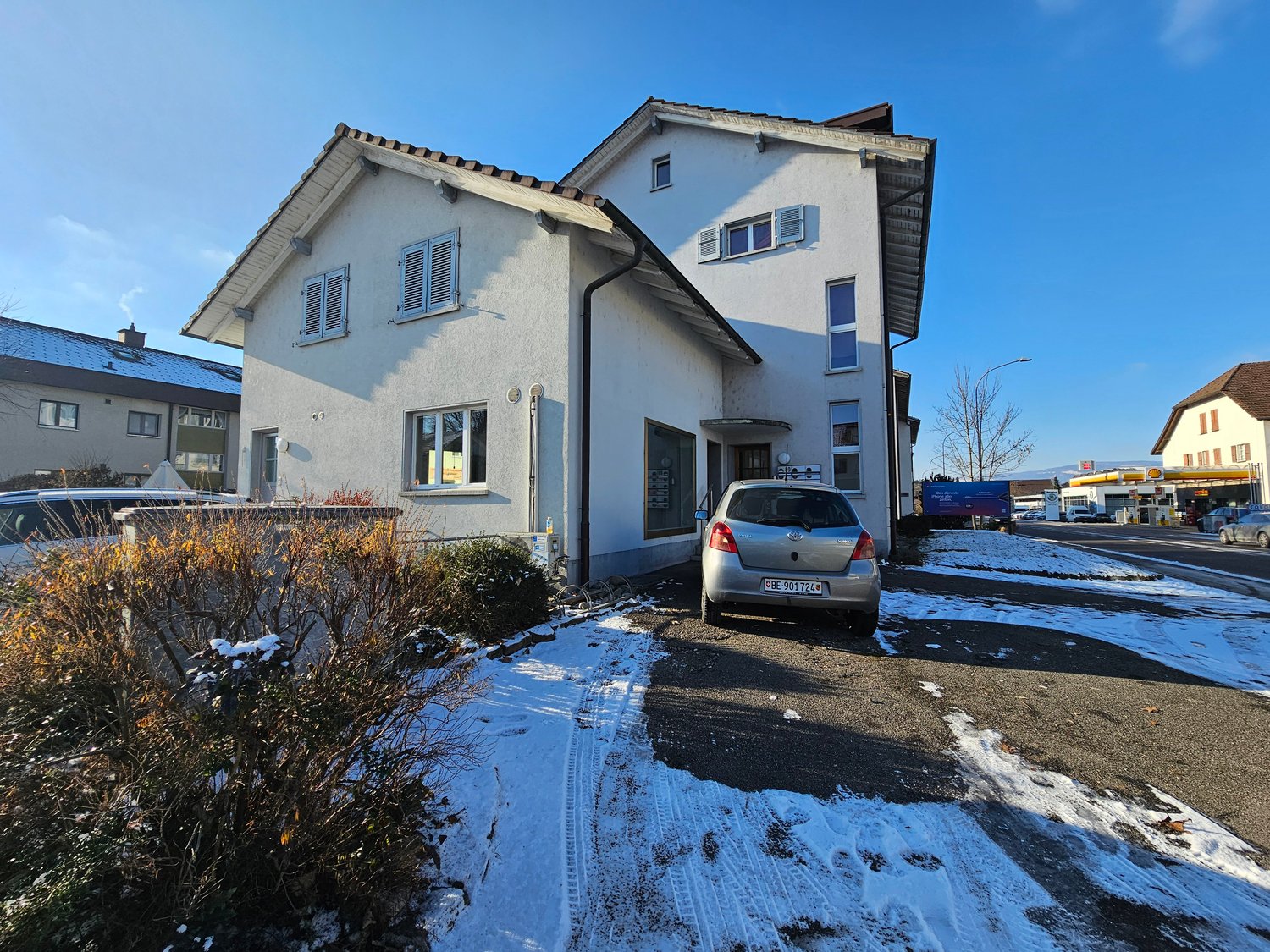 two-story house, white exterior, tiled roof, windows, chimney, snow on ground, car parked in front