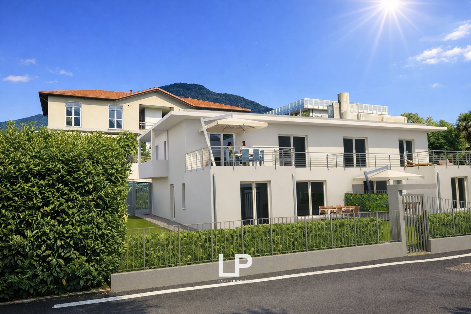 two story white house with red roof, balcony, garden with metal fence, small garden in front of the house, street view