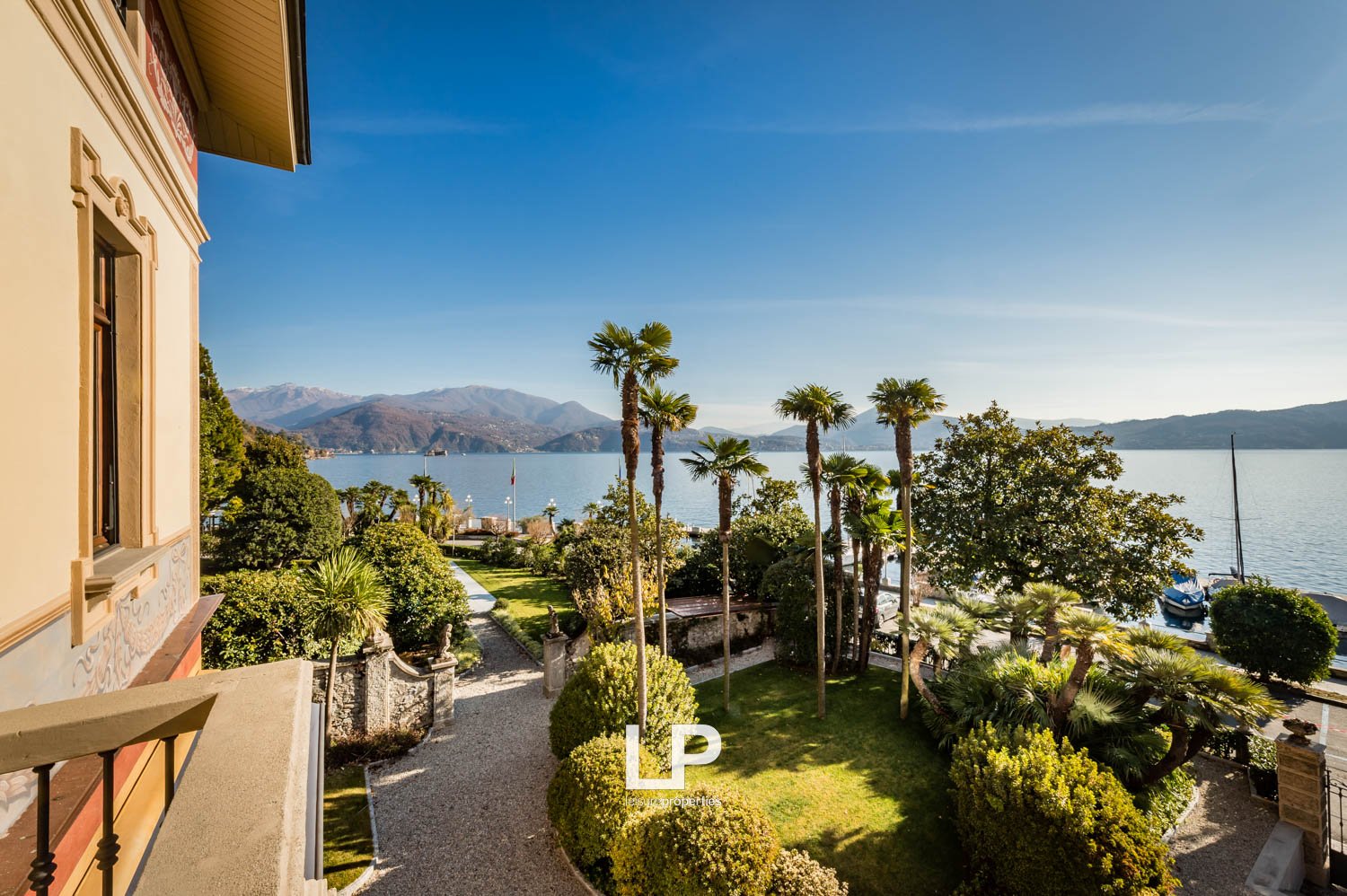 balcony with ocean view, lawn, trees, mountains, mountains in the distance