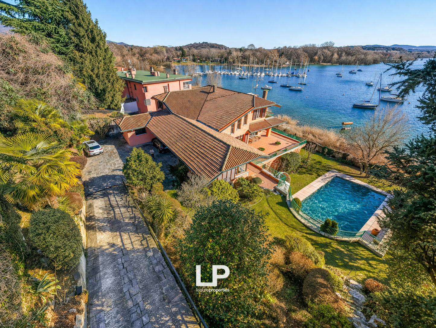 Large house with a swimming pool, located on a hill with a view of the lake