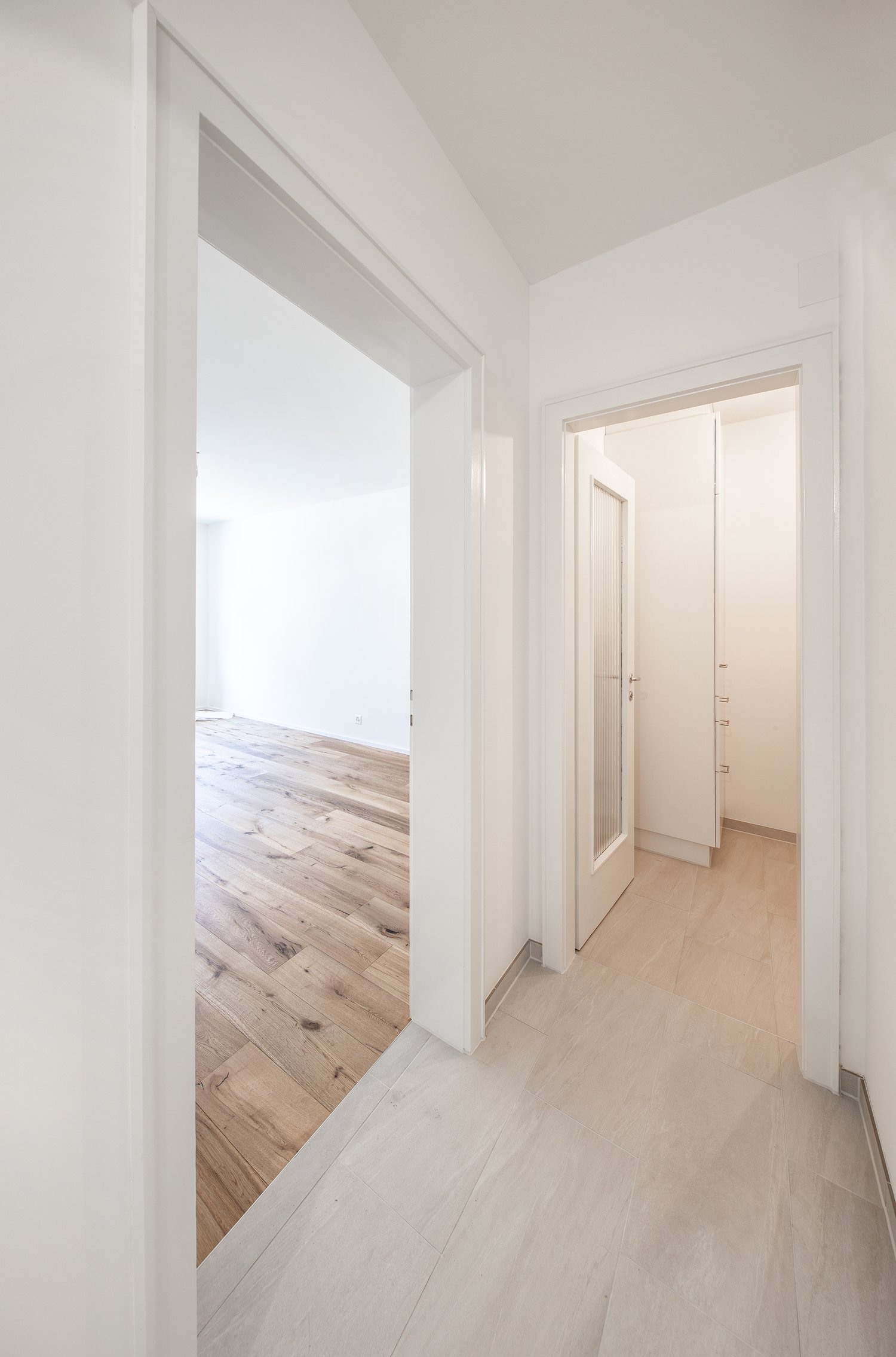 Wooden floor, white walls, open door, minimalist design
