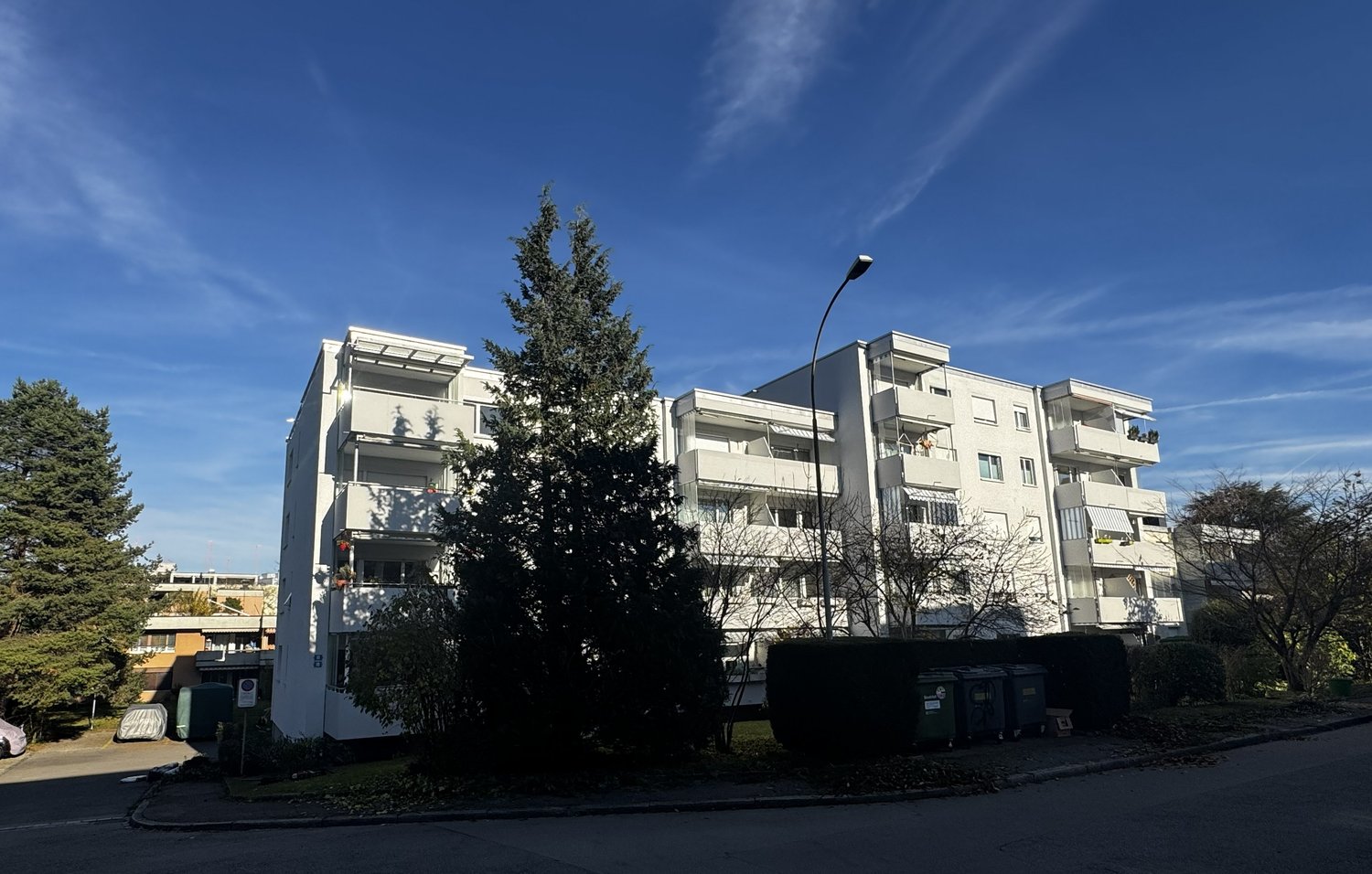 multistory building, balconies, white exterior, street light, trees