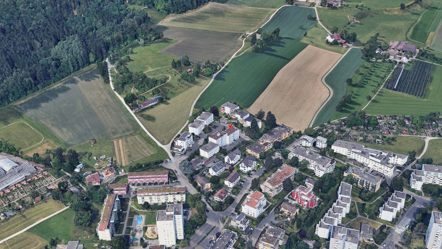 apartment buildings, swimming pool, fields, woods