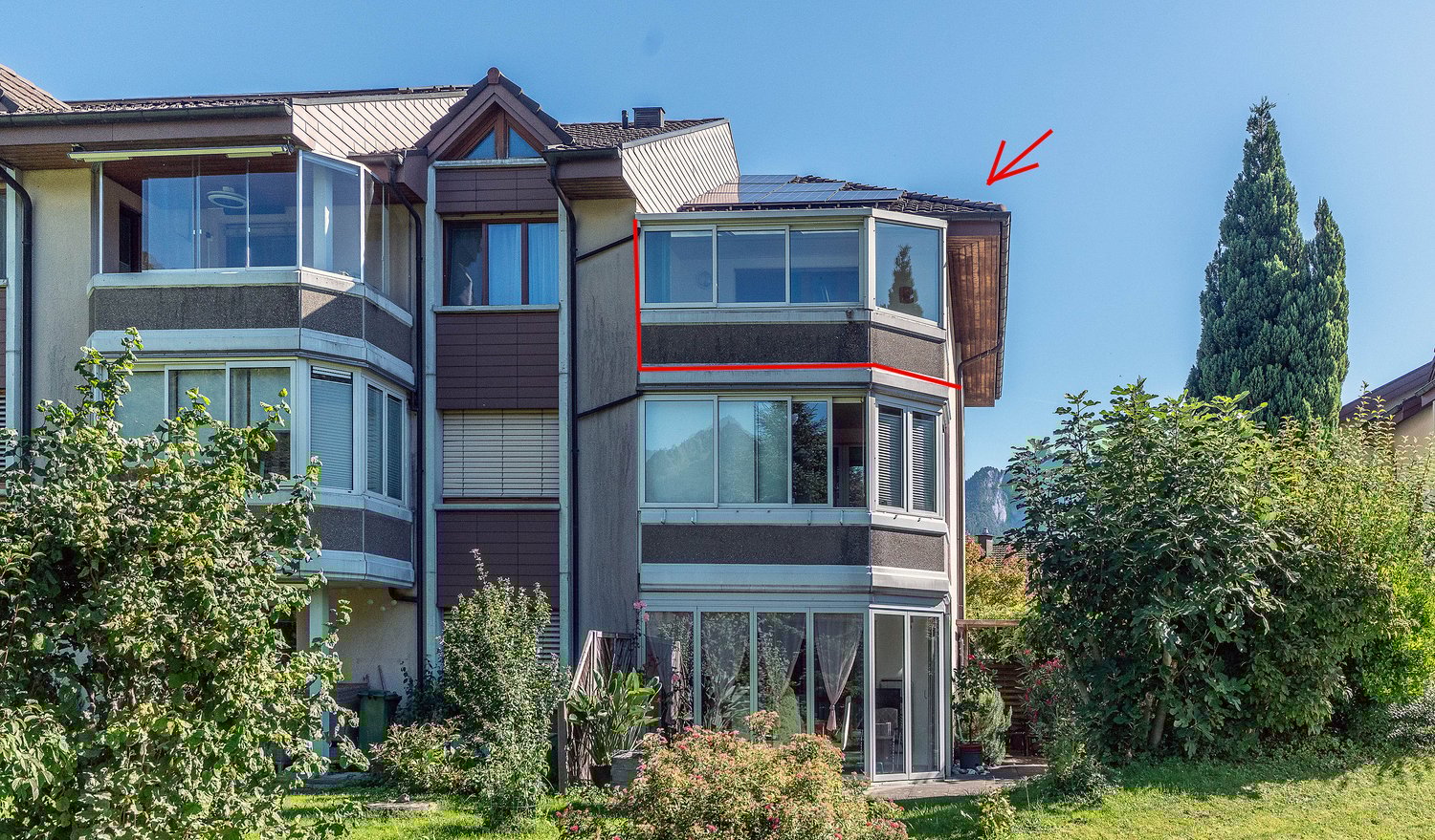 Three-story house with glass balcony, solar panels on the roof, glass windows