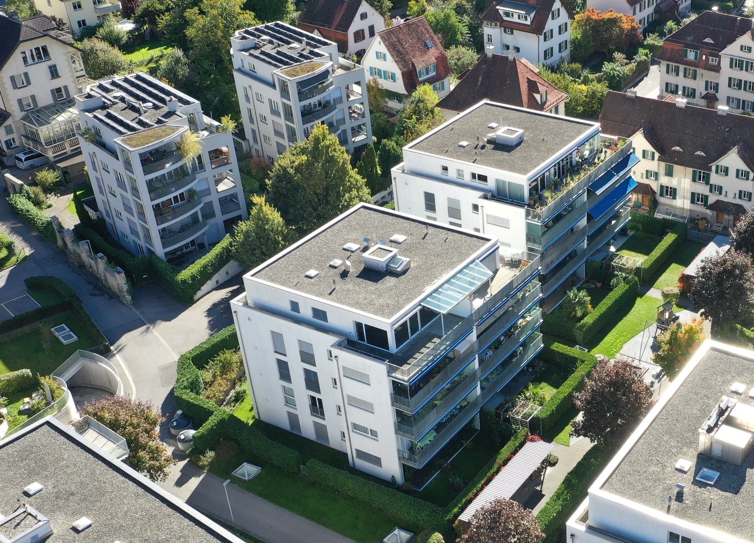 Multiple residential buildings, some with solar panels, balconies, and terrace