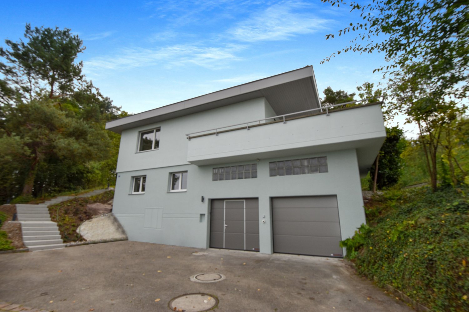 Two-story house, white exterior, two garages, balcony, staircase, driveway