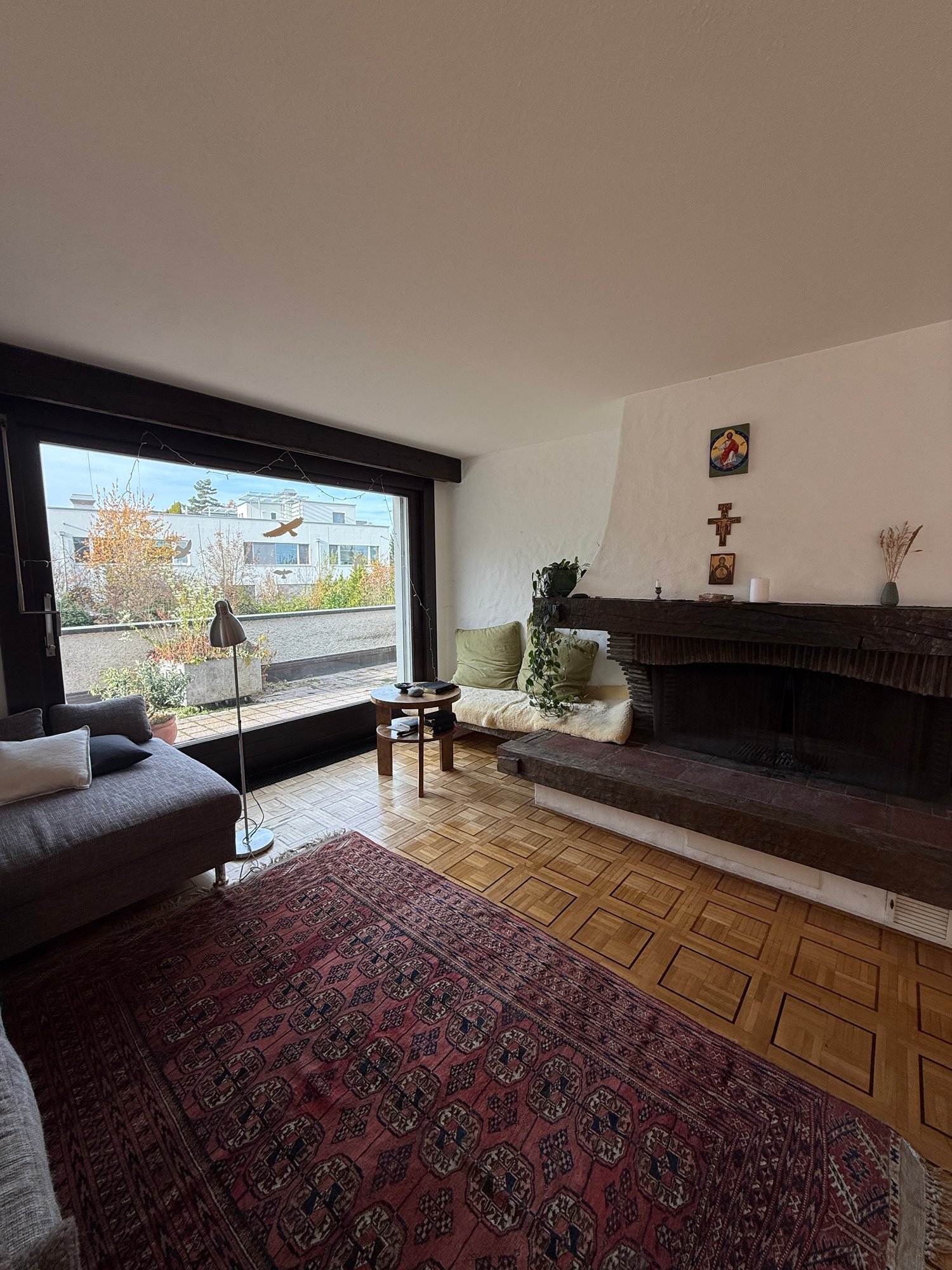 fireplace, couch, rug, lamp, large windows, garden view