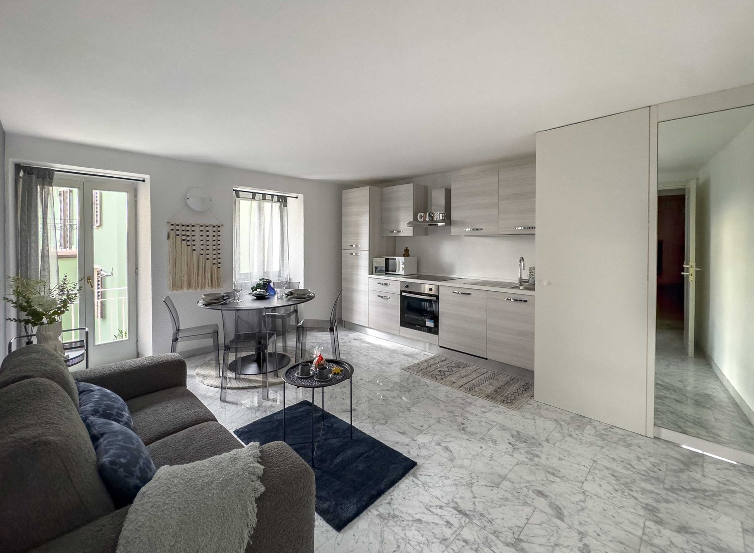 Modern apartment with large living room, open kitchen, dining area, marble floor, modern furniture