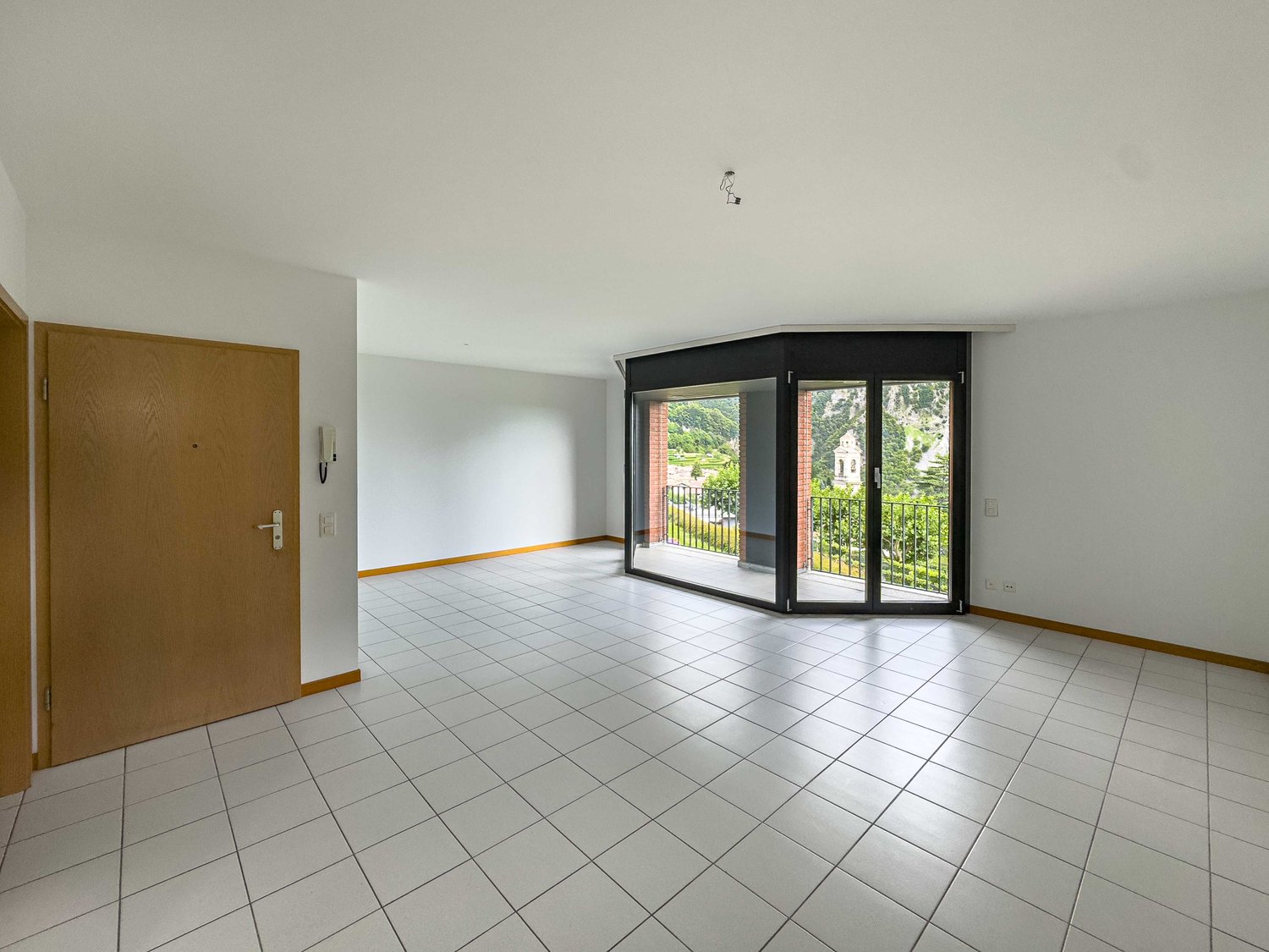 empty room, white tiles, sliding doors, balcony with railings, wooden door