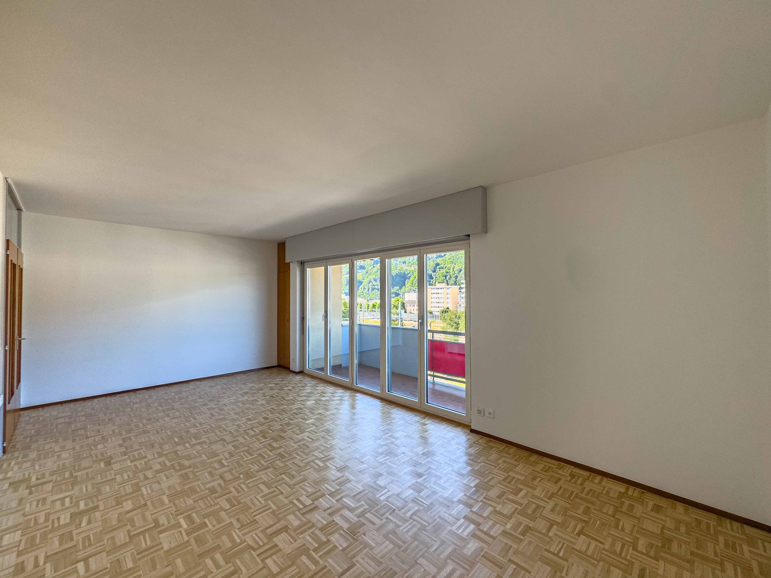 Empty room, balcony, parquet flooring, sliding glass doors