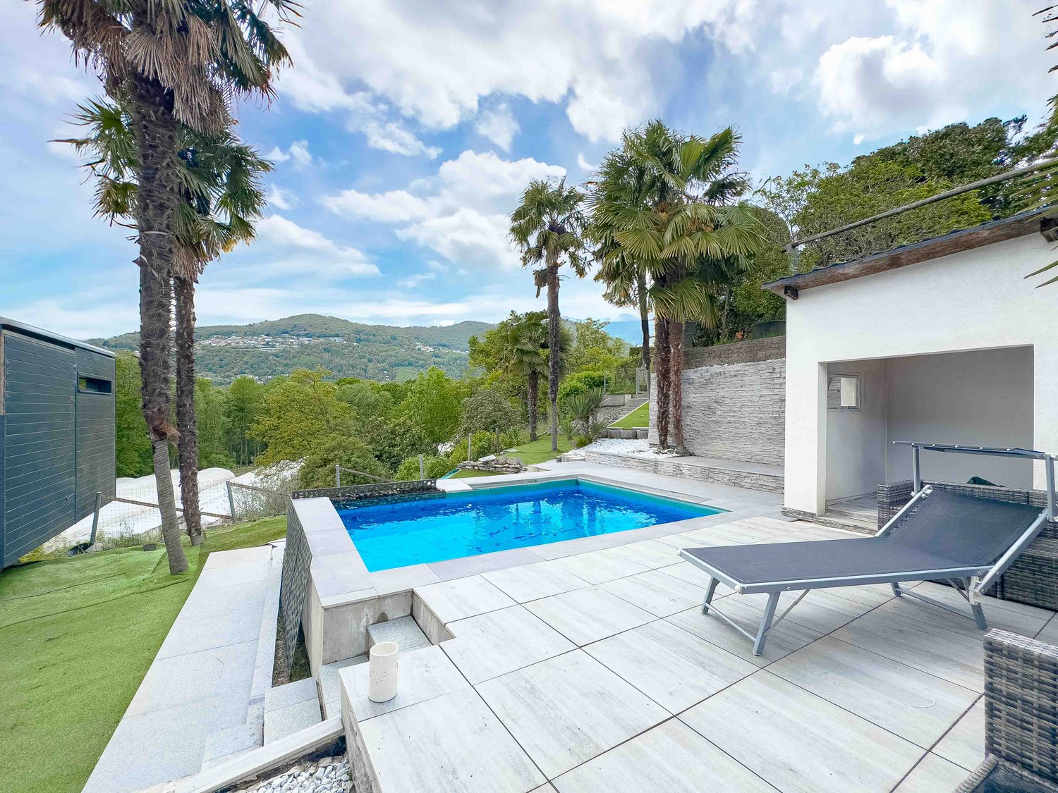 outdoor pool, lounger, lush greenery, scenic mountains