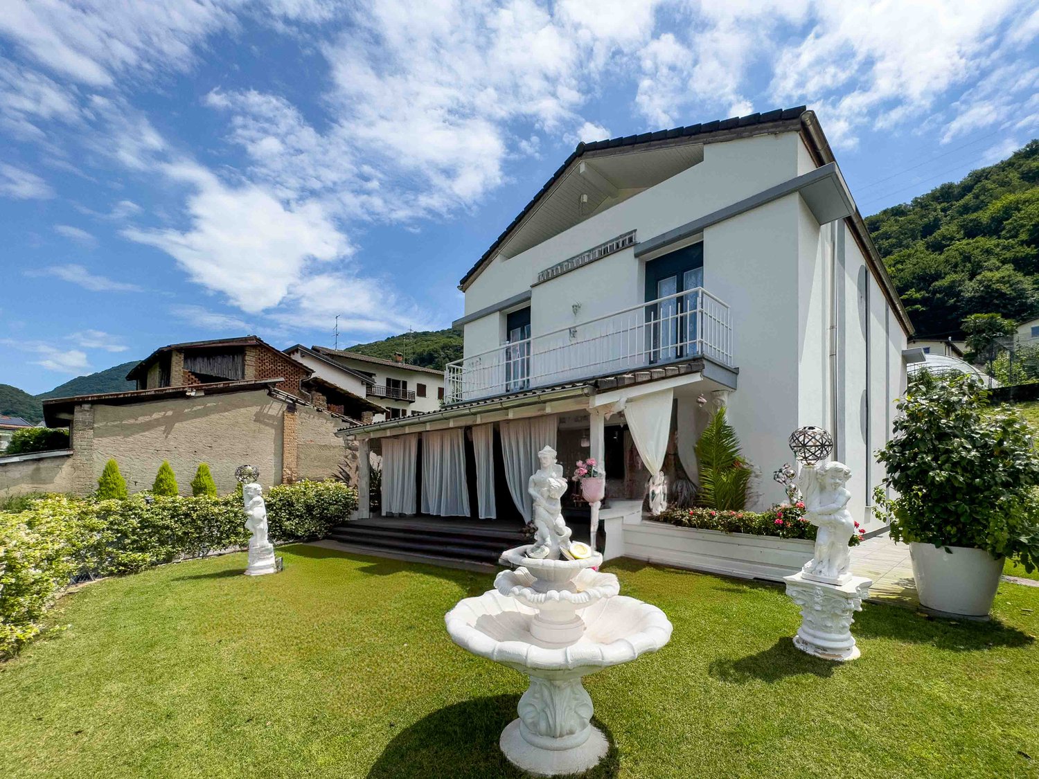 Detached house, large balcony, garden, fountain, statue, green grass, plants, mountain view