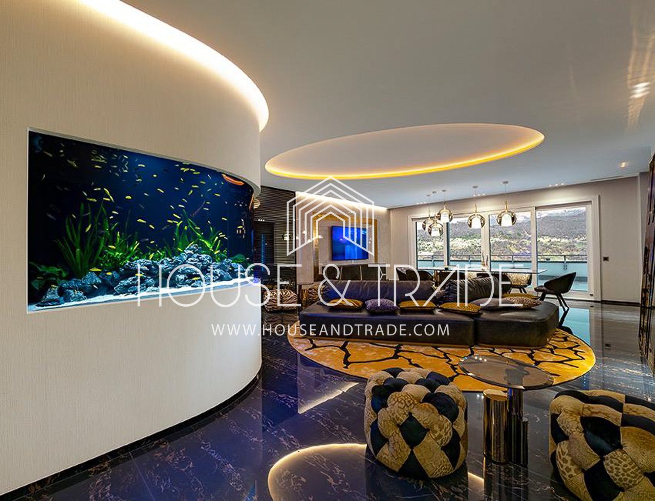 Curved white wall, aquarium, leather sofa, yellow carpet, glass table, chairs, TV