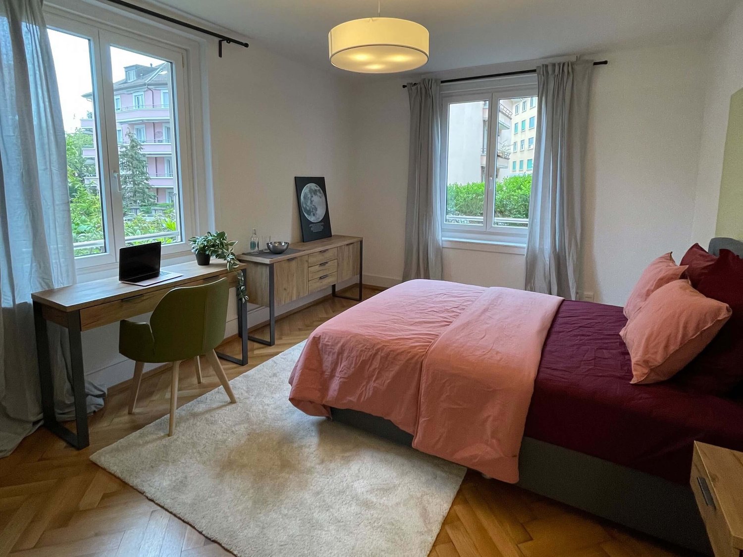 bedroom with bed, desk, chair, rug, window, decorative items, curtains, lamp