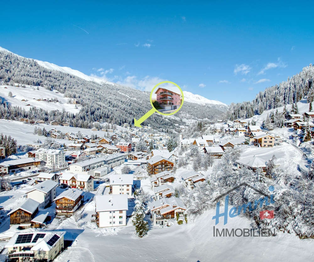 Winter snowy landscape with traditional wooden houses and a pointed arrow highlighting a building in the center