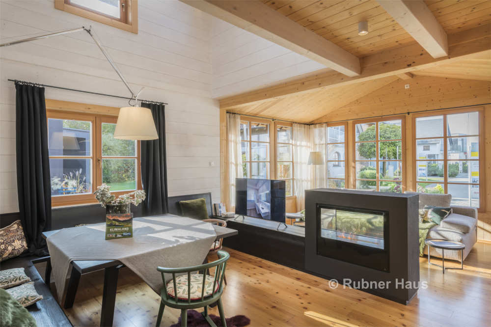 wooden floor, open-plan kitchen, dining table, living room bench, TV, fireplace, large windows