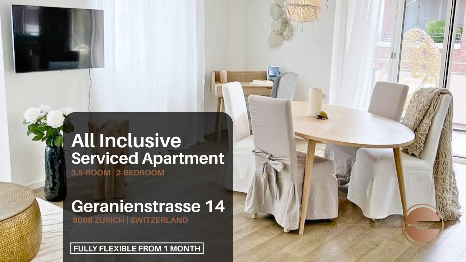 A dining room with a table and chairs, white walls, wooden floor, white curtains, flowers in a vase, a mounted television, a lamp, and a cushioned chair