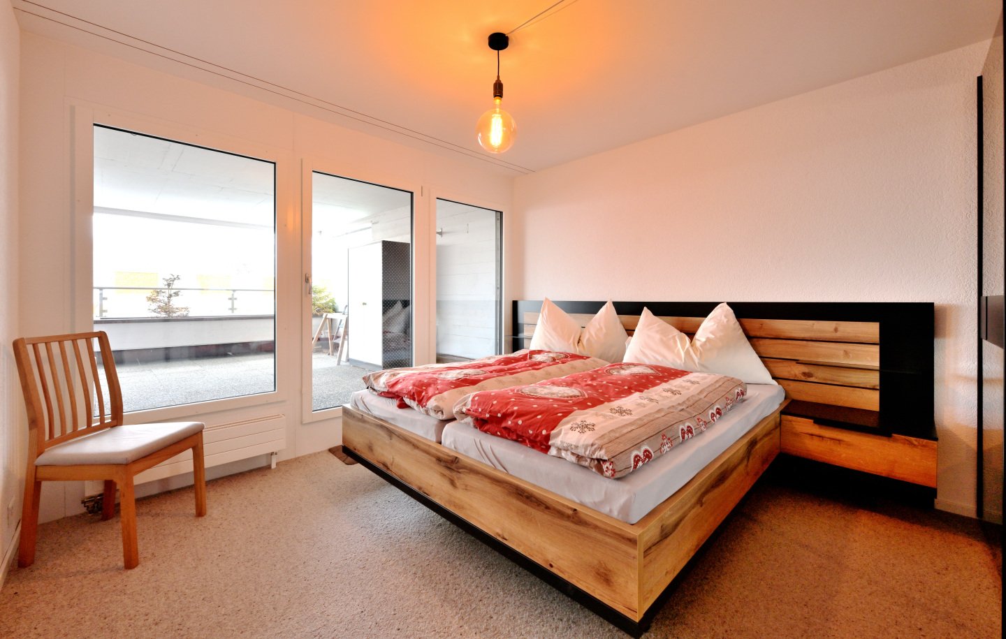 wooden bed, double bed, white bedding, wooden chair, floor lamp, sliding glass door, balcony