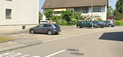 Multiple parking spots with cars parked on both sides of the street.