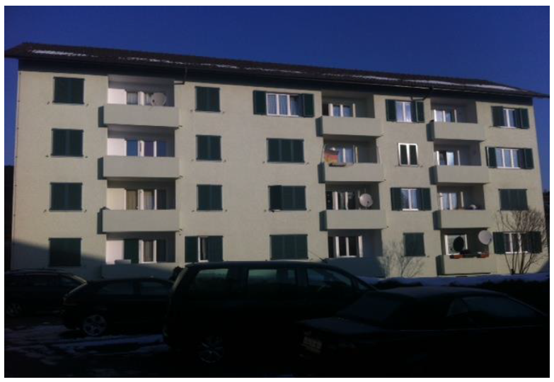 5 story residential building with balconies, windows, cars parked in front