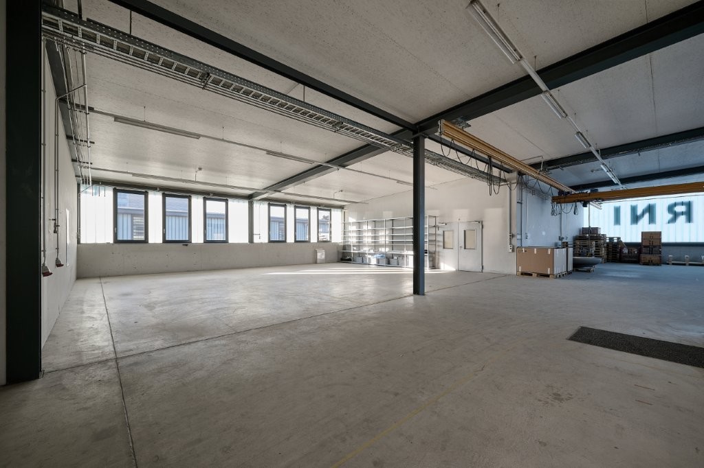 empty room, concrete floor, windows, metal ceiling beams, storage shelves