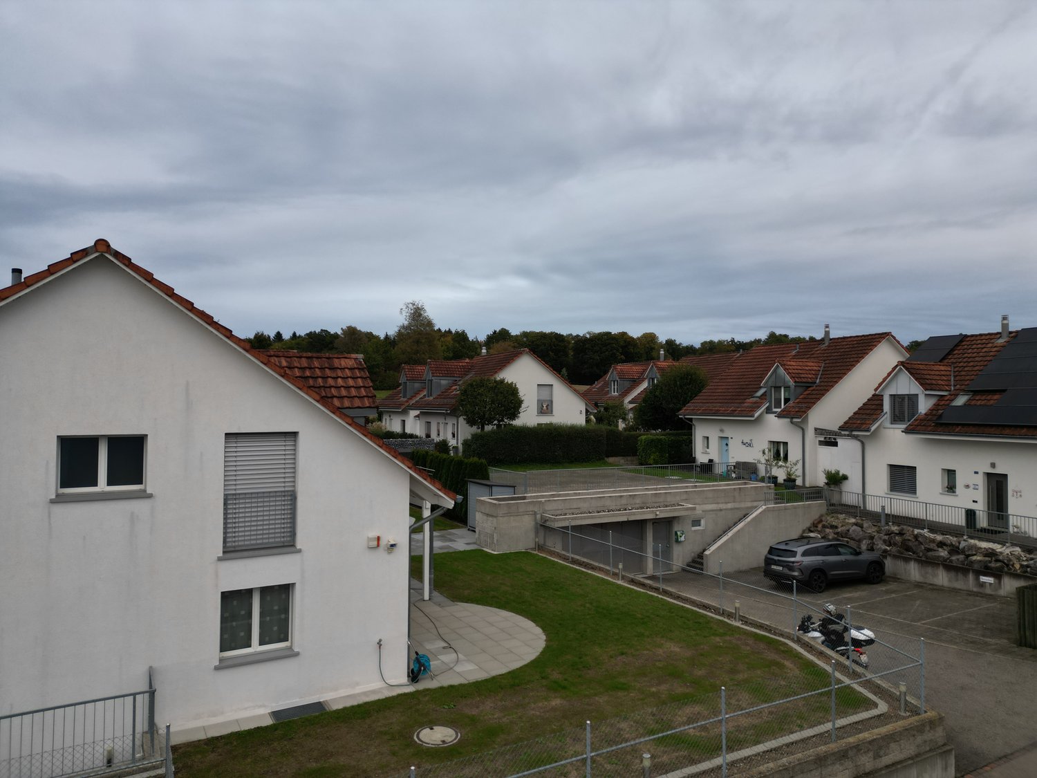 modern single-family house, white exterior, red roof, 2 car parking space, green lawn