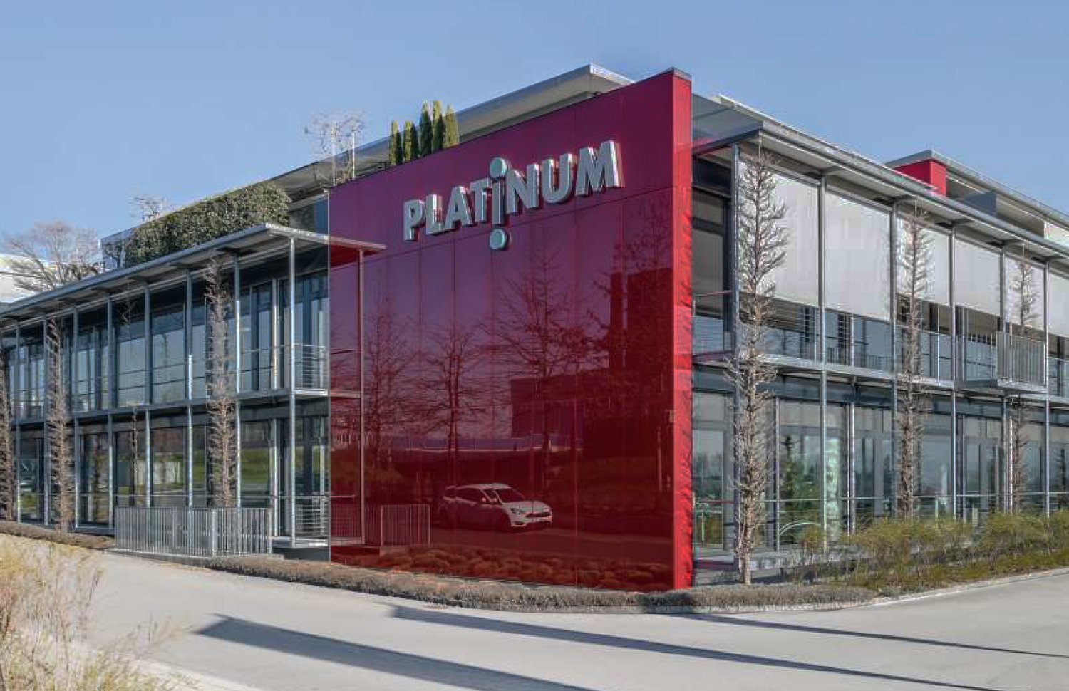modern office building, red facade, glass windows, metal railings, car reflection