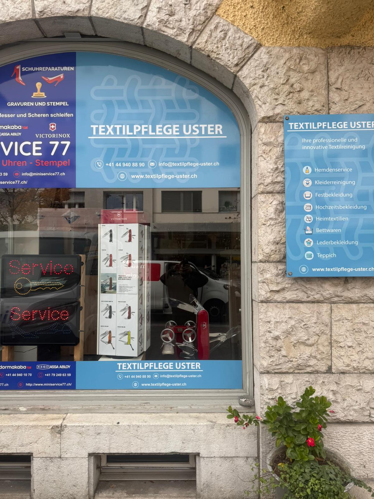 Signs advertising services for shoe repair, watch servicing, and textile care.