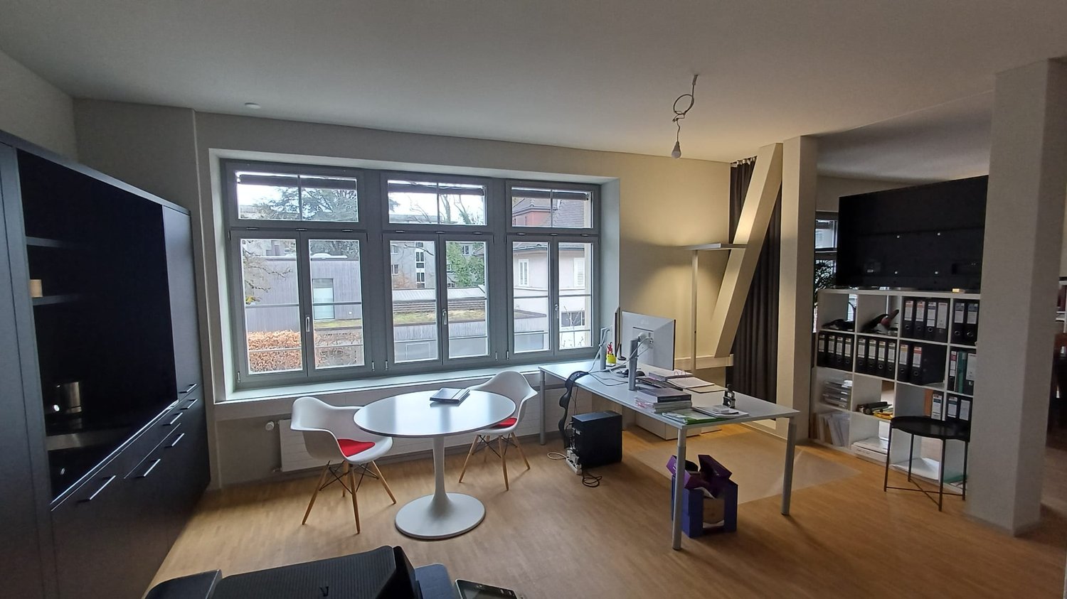 office room with desk, chairs, computer, books, storage boxes, shelves, radiator, window