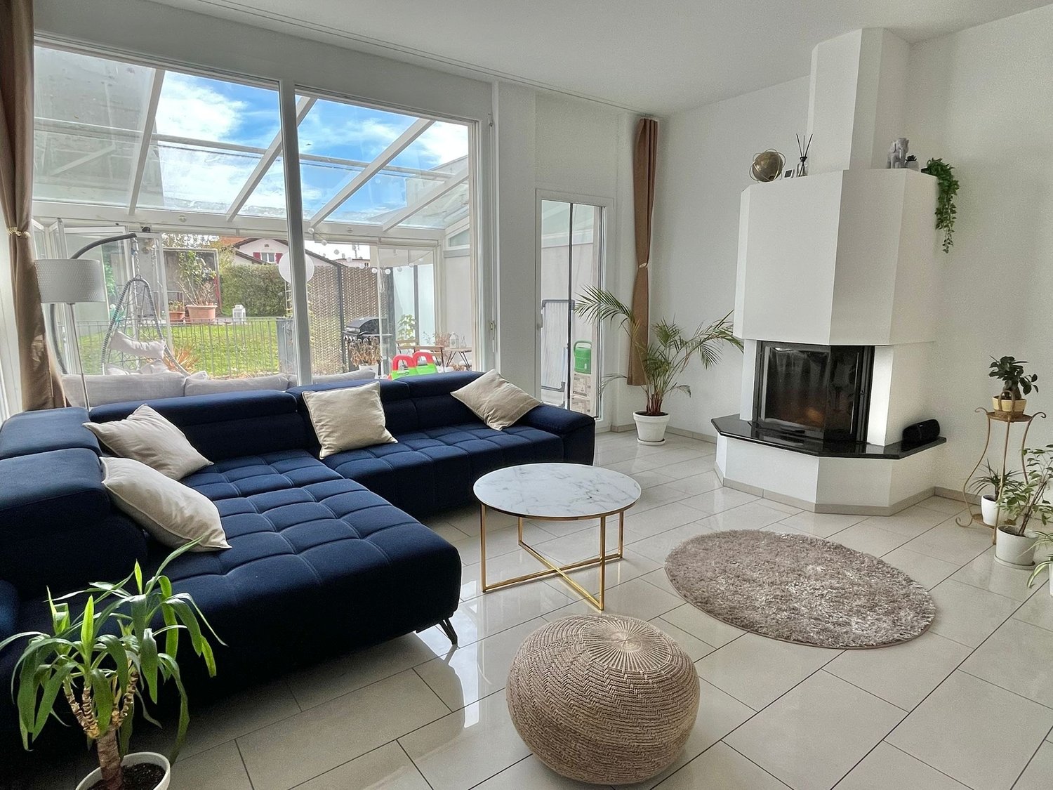 blue sofa, coffee table, fireplace, lamps, rug, plants