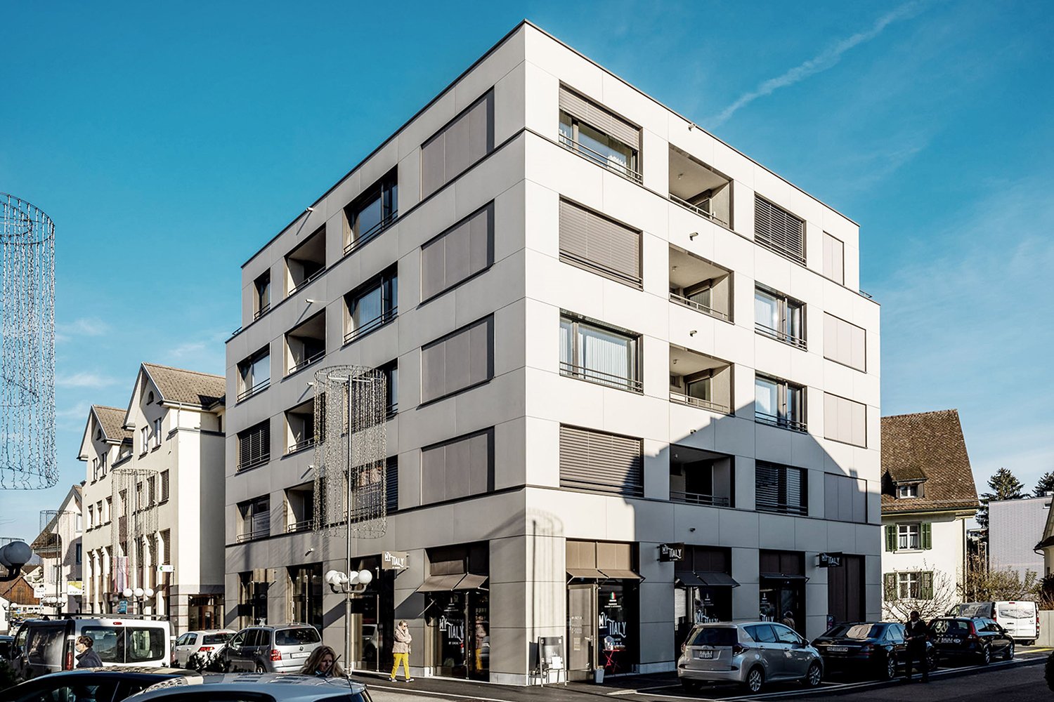 Modern white building with multiple balconies and windows